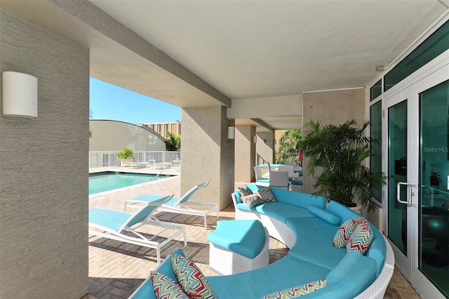 view of patio / terrace featuring french doors, outdoor lounge area, and a fenced in pool