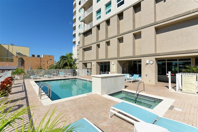 view of pool featuring a hot tub and a patio area