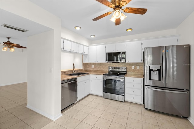 kitchen featuring tasteful backsplash, white cabinetry, sink, and appliances with stainless steel finishes