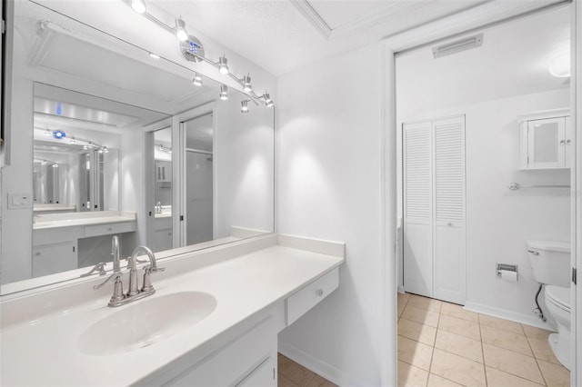 bathroom featuring tile patterned flooring, vanity, a textured ceiling, and toilet