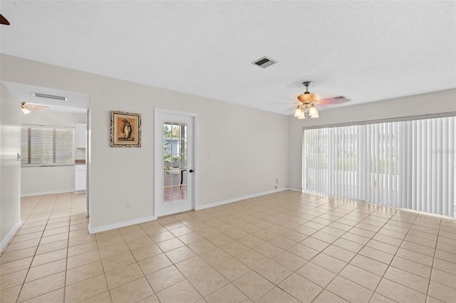 tiled empty room featuring a textured ceiling and ceiling fan