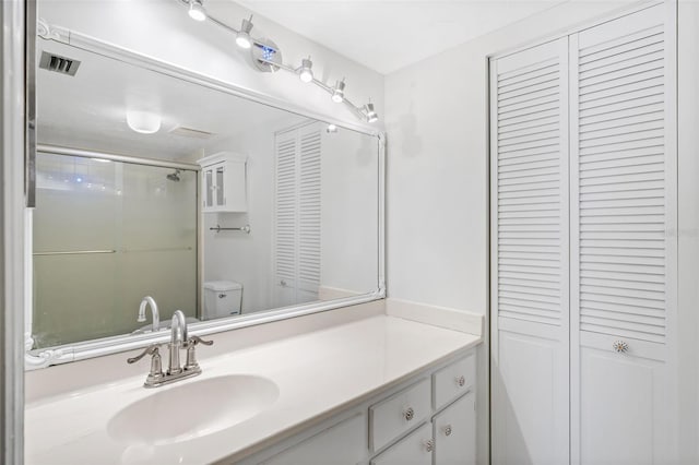 bathroom with vanity, toilet, and walk in shower