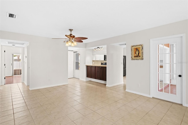 unfurnished living room with light tile patterned floors and ceiling fan