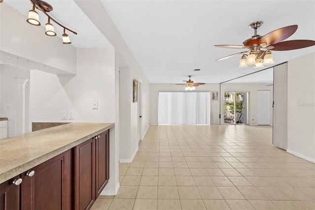 interior space with ornate columns, ceiling fan, and light tile patterned floors