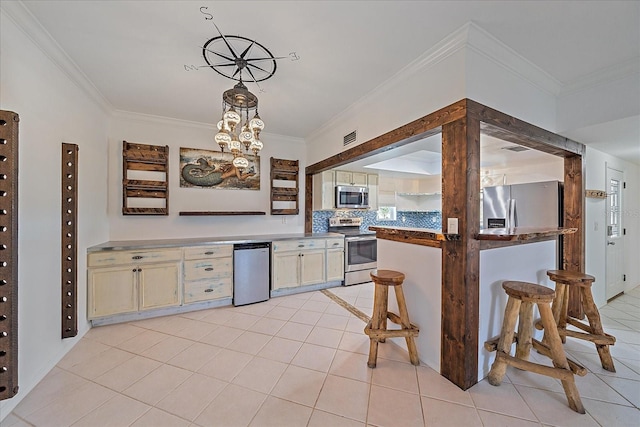 kitchen featuring a notable chandelier, light tile floors, tasteful backsplash, appliances with stainless steel finishes, and hanging light fixtures