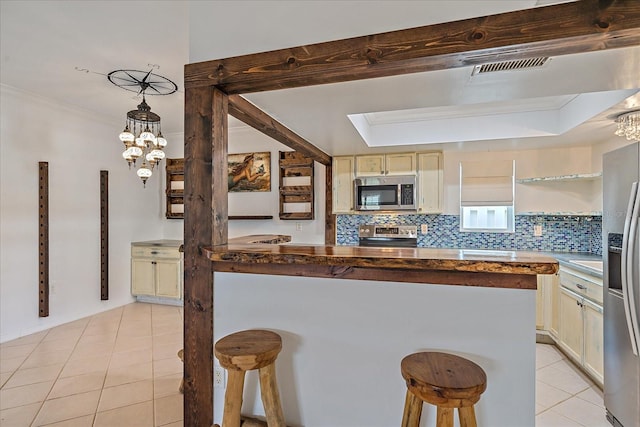 kitchen with a kitchen bar, hanging light fixtures, backsplash, and stainless steel appliances