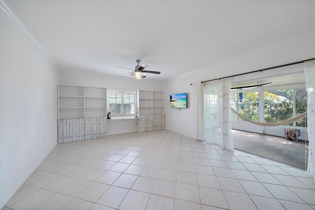 tiled empty room featuring built in features, ornamental molding, ceiling fan, and a wealth of natural light