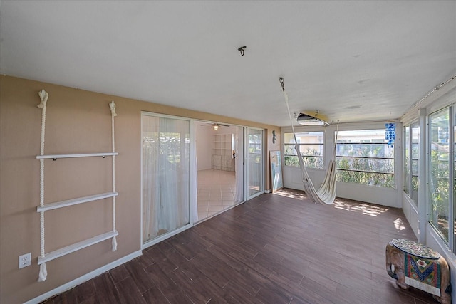 unfurnished sunroom featuring ceiling fan and a wealth of natural light