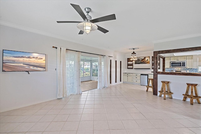 living room featuring ceiling fan with notable chandelier, light tile flooring, and ornamental molding