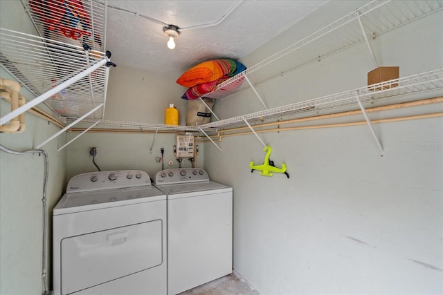 clothes washing area featuring electric dryer hookup, washer and clothes dryer, and a textured ceiling