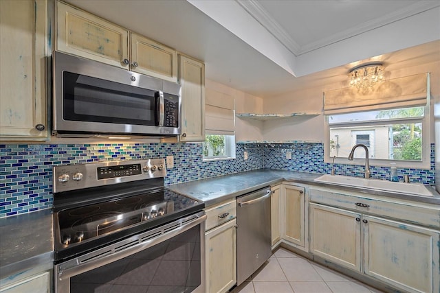 kitchen featuring light tile floors, tasteful backsplash, ornamental molding, appliances with stainless steel finishes, and sink