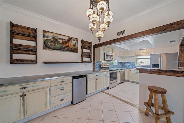 kitchen with a chandelier, pendant lighting, stainless steel appliances, ornamental molding, and backsplash