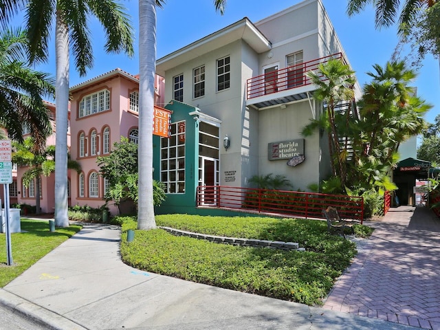 view of front of home featuring a balcony and a front lawn