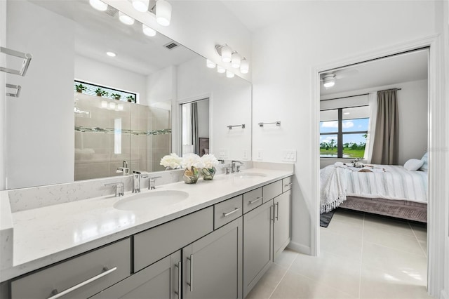 bathroom with a tile shower, tile floors, dual sinks, and vanity with extensive cabinet space