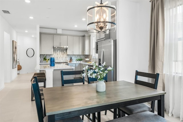 tiled dining room featuring a notable chandelier