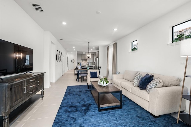 living room with light tile flooring and a notable chandelier