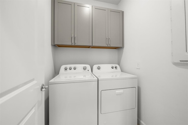 laundry area with washing machine and clothes dryer and cabinets