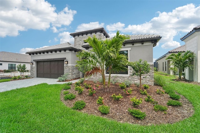 mediterranean / spanish house with a garage and a front lawn