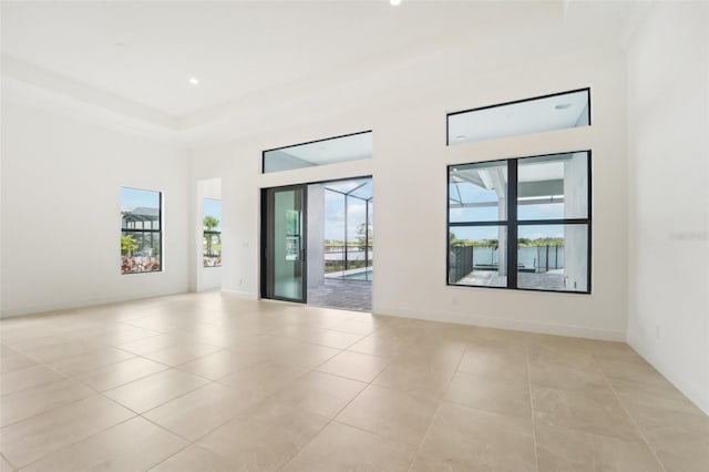 unfurnished room featuring light tile patterned floors and a high ceiling