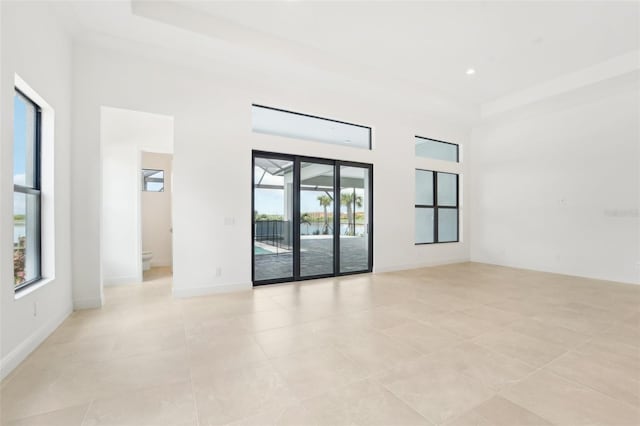 tiled spare room featuring a high ceiling