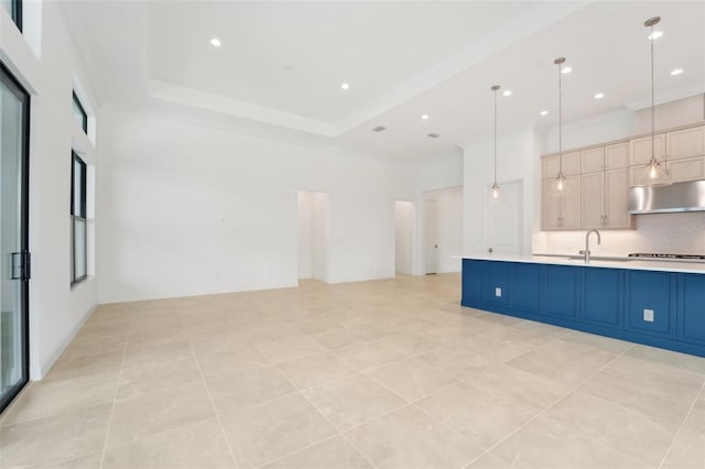 interior space with decorative backsplash, light tile patterned floors, blue cabinetry, decorative light fixtures, and cooktop