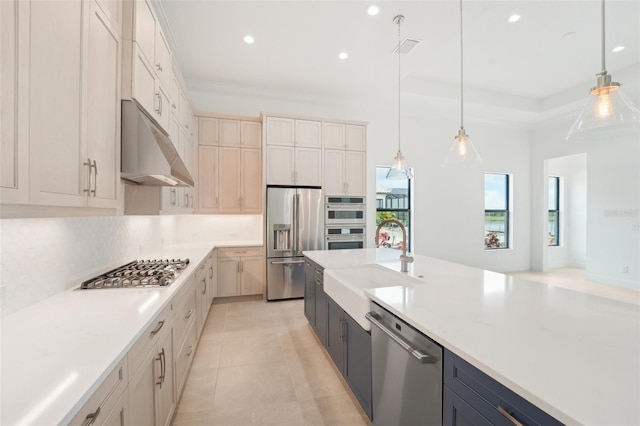 kitchen with light stone countertops, sink, hanging light fixtures, light tile patterned floors, and appliances with stainless steel finishes