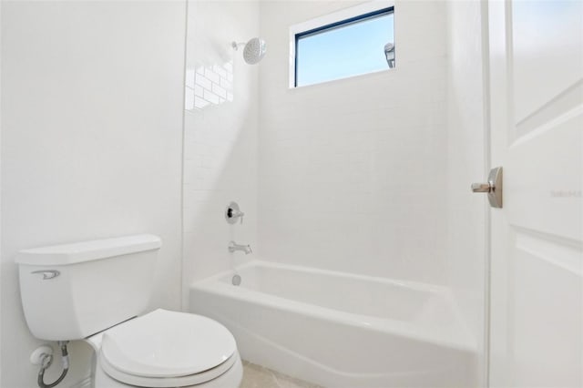 bathroom with tiled shower / bath combo and toilet