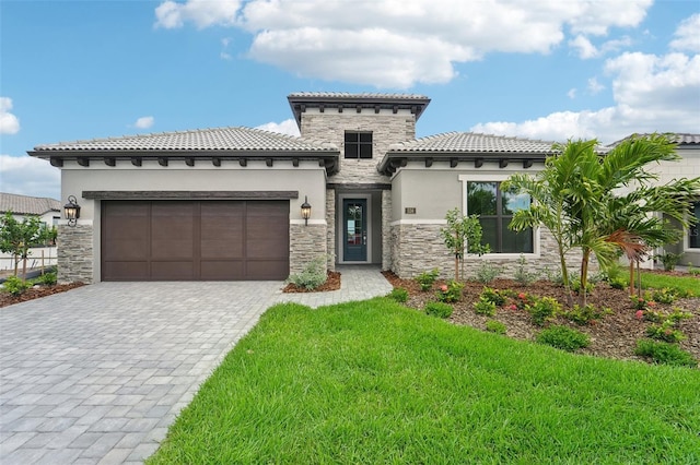 mediterranean / spanish home featuring a garage and a front lawn