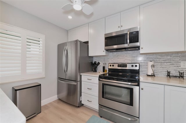 kitchen with ceiling fan, white cabinets, backsplash, stainless steel appliances, and light wood-type flooring