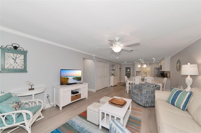 living room with ornamental molding, ceiling fan with notable chandelier, sink, and light wood-type flooring