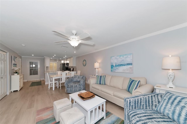 living room featuring ceiling fan, light hardwood / wood-style flooring, and crown molding