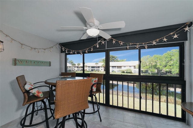 tiled dining space featuring ceiling fan and a healthy amount of sunlight