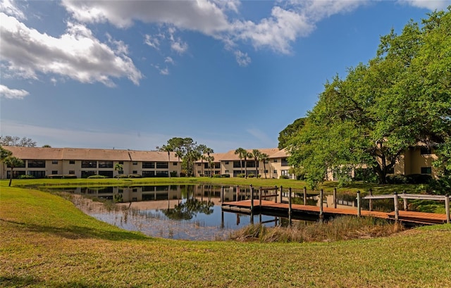 view of dock featuring a water view and a lawn