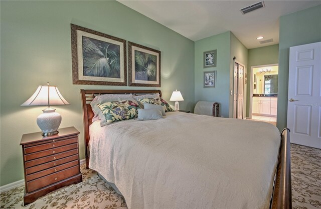 bedroom with light colored carpet and ensuite bathroom