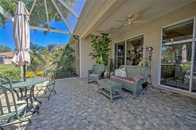 view of patio / terrace featuring ceiling fan and glass enclosure