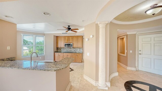 401 N Point Rd Unit 301, Osprey, FL 34229 - kitchen featuring light tile flooring, ceiling fan, backsplash, ornate columns, and light stone counters