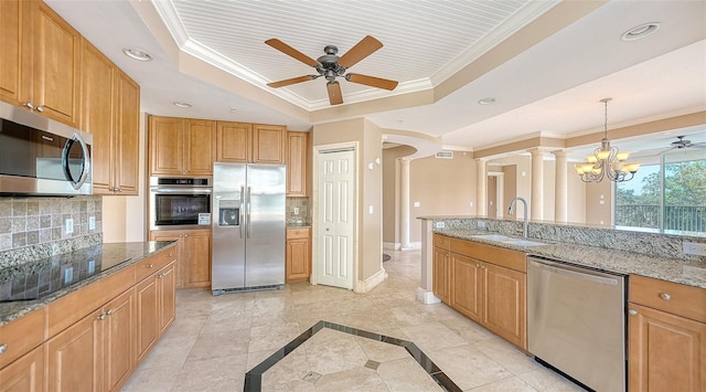 401 N Point Rd Unit 301, Osprey, FL 34229 - kitchen with ceiling fan with notable chandelier, appliances with stainless steel finishes, sink, a raised ceiling, and light stone counters