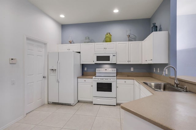 kitchen featuring light tile flooring, kitchen peninsula, white appliances, white cabinets, and sink