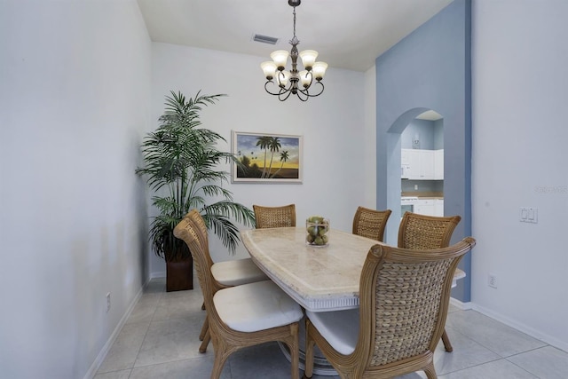 dining room with light tile flooring and a notable chandelier