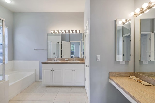 bathroom with double sink, a bathing tub, tile floors, and vanity with extensive cabinet space