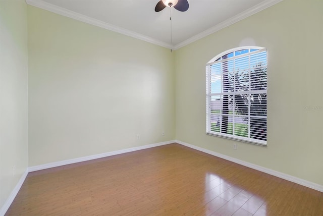 spare room with baseboards, ornamental molding, ceiling fan, and wood finished floors