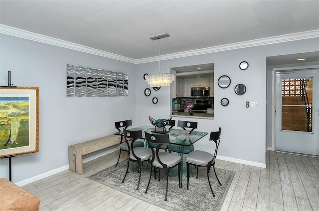 dining room with a chandelier, crown molding, and light hardwood / wood-style flooring