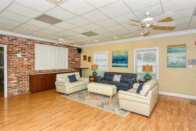 living room featuring brick wall, ornamental molding, wood-type flooring, and ceiling fan