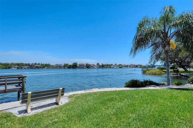 view of dock featuring a water view and a yard