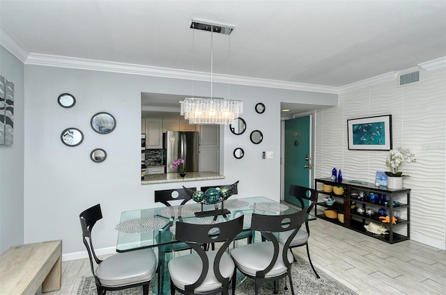 dining space with crown molding, a chandelier, and light hardwood / wood-style flooring