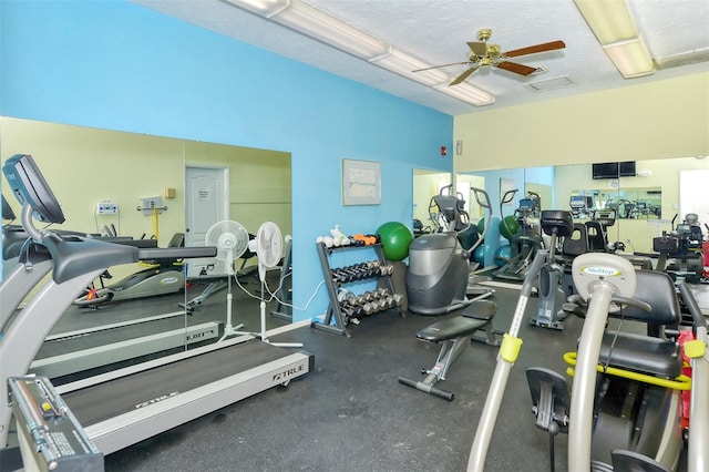 workout area with ceiling fan and a textured ceiling