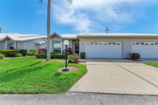 single story home with a garage and a front lawn