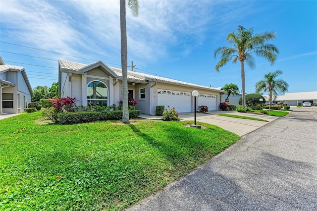 single story home with a garage and a front lawn