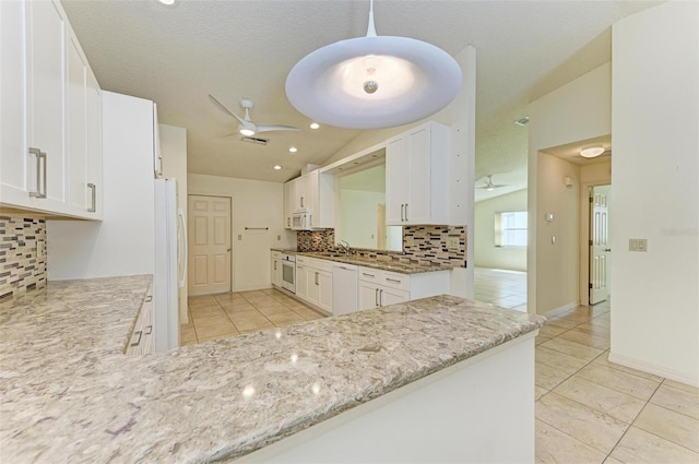 kitchen featuring vaulted ceiling, backsplash, ceiling fan, white cabinets, and white appliances