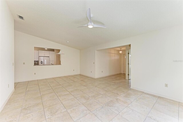 tiled empty room with a textured ceiling, ceiling fan, and vaulted ceiling